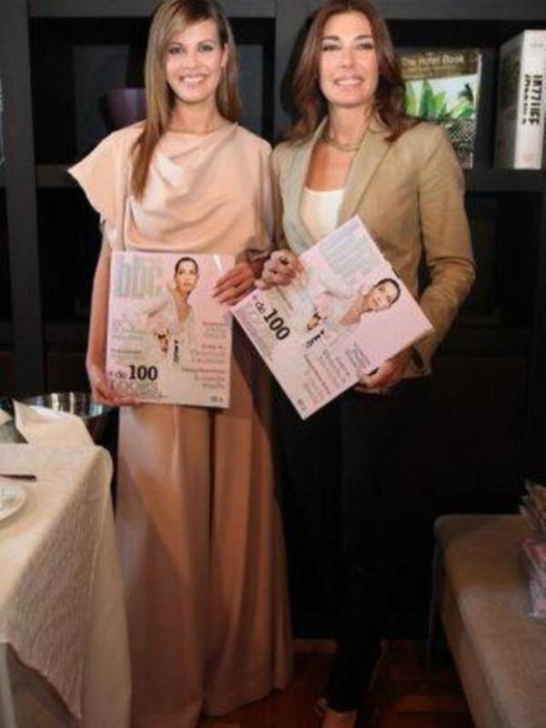 Dos mujeres presentan un libro titulado '100' en un evento formal.