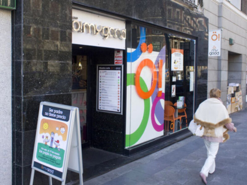 Tienda 'amygood' en una calle con una persona caminando por delante.