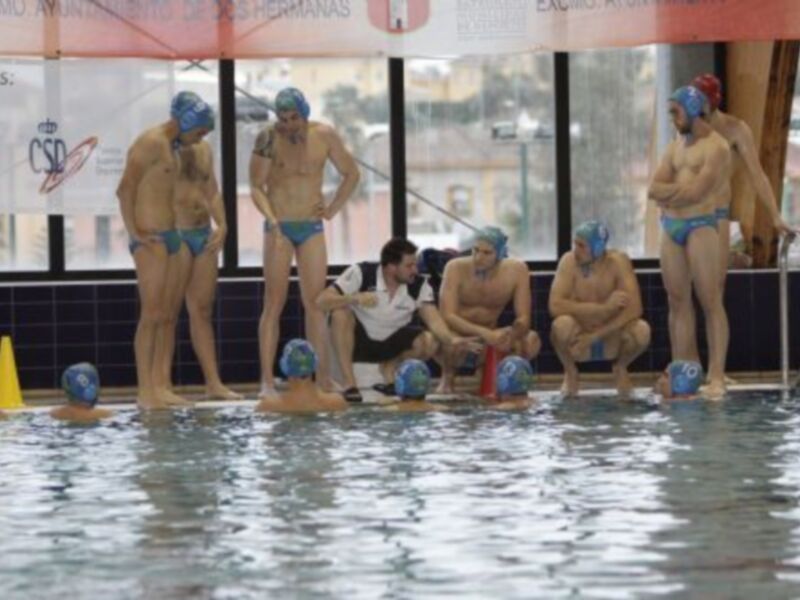 Equipo de waterpolo en el borde de una piscina, preparándose para un partido.