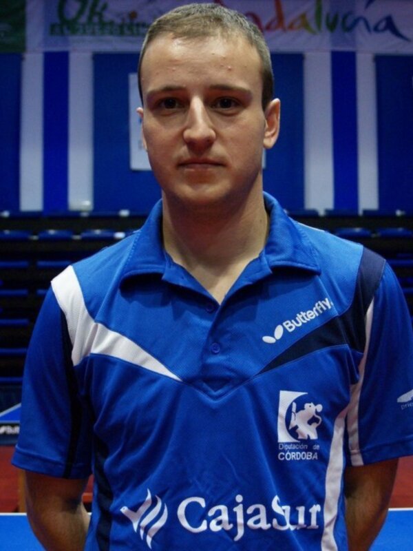 Joven jugador de tenis de mesa con camiseta azul y logo de CajaSur en el estadio de Córdoba.