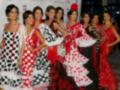 Modelos vestidas de trajes típicos flamencos posan en un evento.