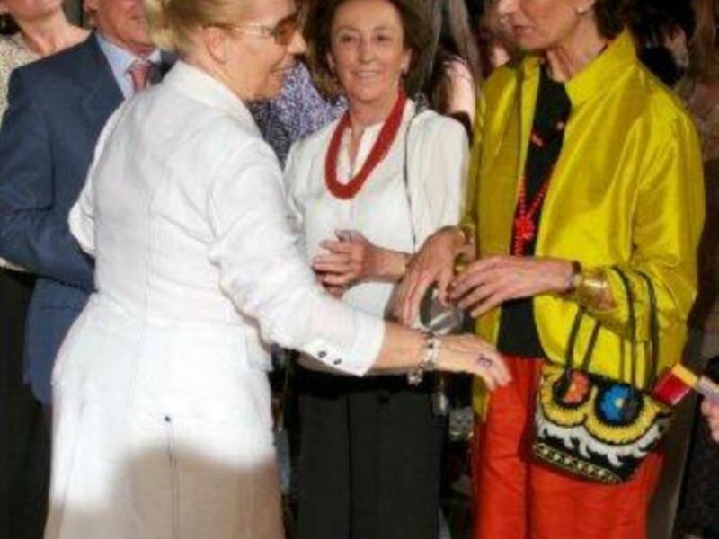 Mujeres intercambiando relojes en un evento social formal.