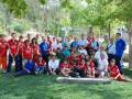 Grupo de jóvenes en camisetas rojas posando para una foto en un parque.