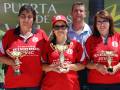 Tres personas en camisetas rojas con trofeos, posiblemente ganadores de un torneo deportivo.