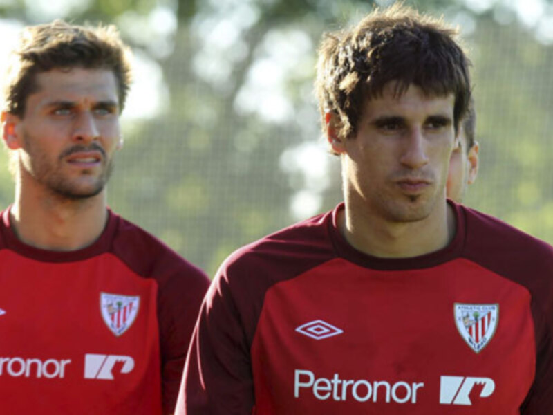 Dos jugadores del Athletic Club de Bilbao en un entrenamiento con camisetas rojas y logos de Petronor.