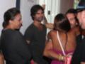 Una celebración con amigos, una mujer sonríe mientras se abraza con un hombre. La imagen muestra a varias personas en una fiesta, con una mujer con un vestido rosa y otro hombre con una camiseta negra.