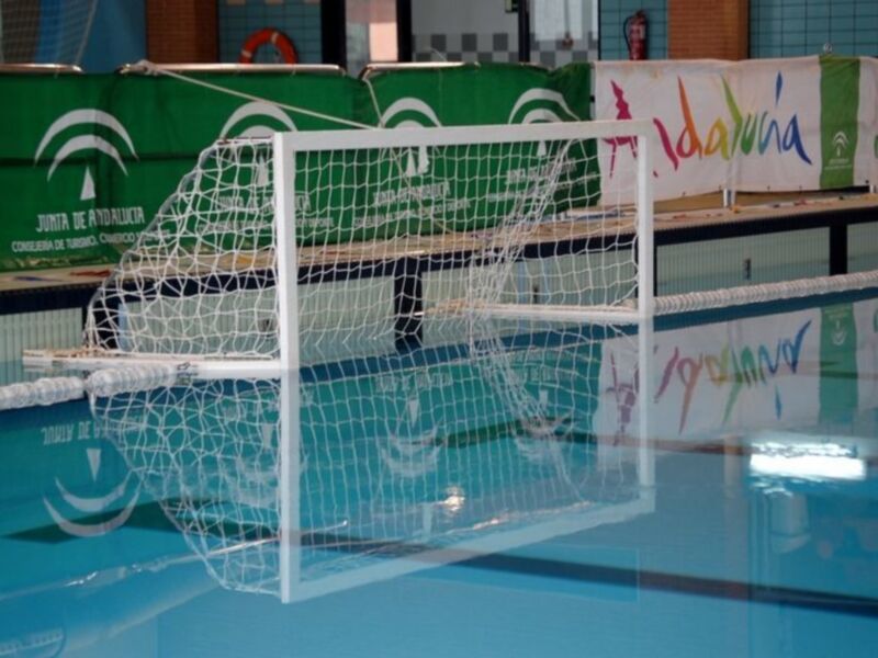 Un gol de voleibol en una piscina con banners publicitarios a los lados.