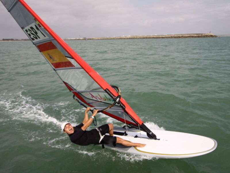 Windsurfing action in Spain, with a Spanish flag sail and a smile on the face.