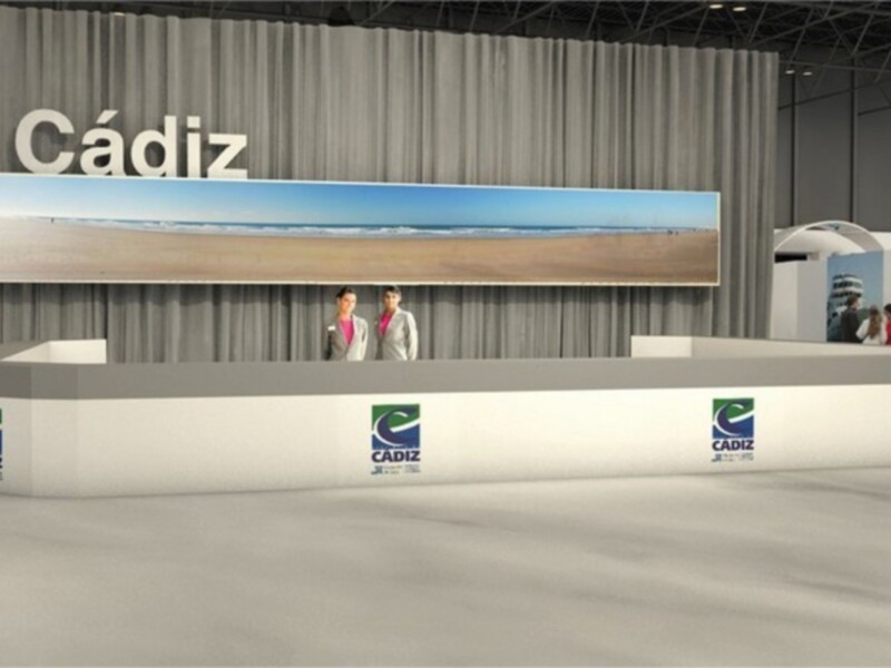 Stand promocional de Cádiz con imagen de playa y logotipos en un evento.