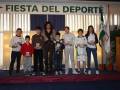 Fiesta del Deporte: Niños ganadores de una competición deportiva en un escenario con decoración festiva.