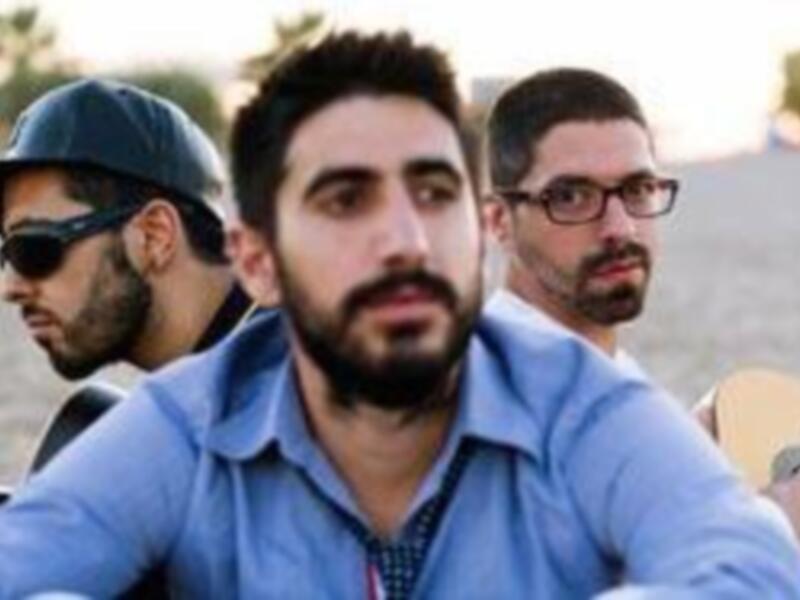 Tres amigos disfrutan de un día en la playa, con una vista maravillosa y música en el aire.