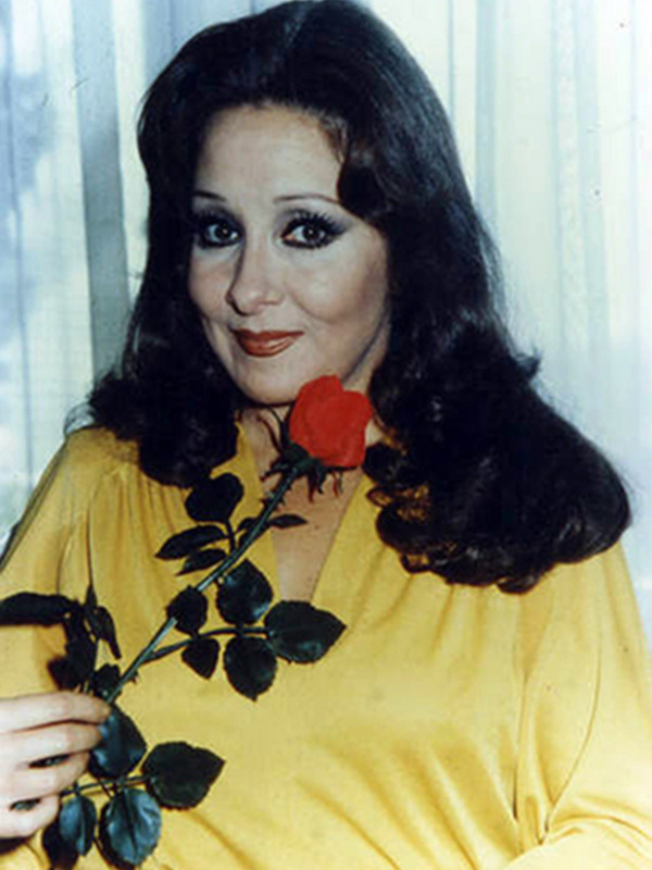 Retrato de mujer con vestido amarillo y rosa roja, década de 1970.