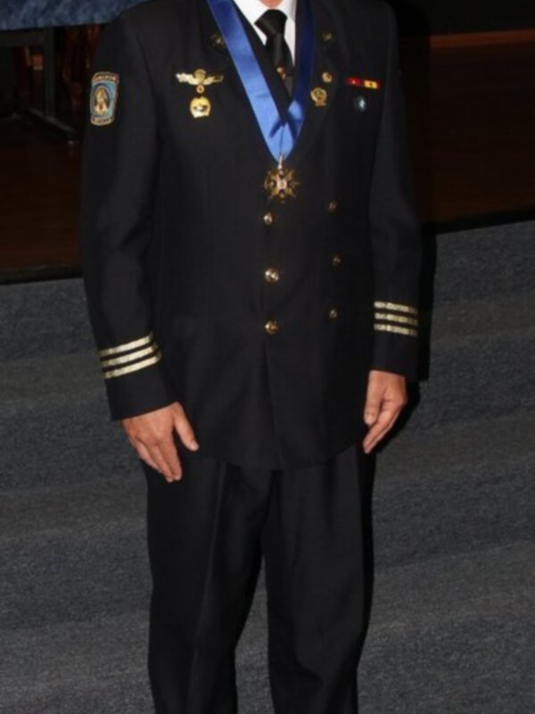 Un hombre en uniforme militar, posando con orgullo. La imagen muestra detalles de su uniforme y medallas, enfatizando la importancia de la ceremonia o celebración.