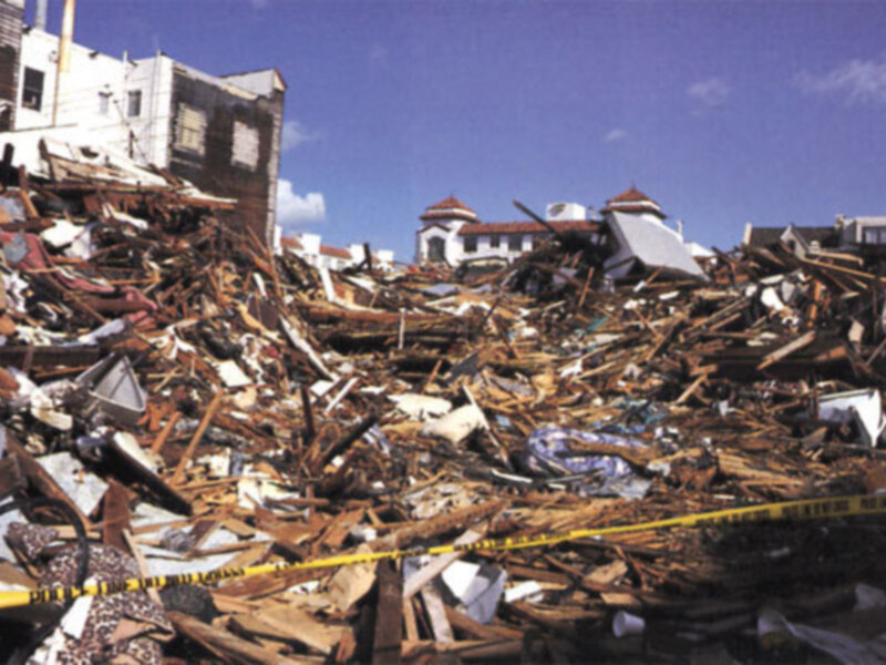 Derrumbe de edificios en la ciudad, con escombros y estructuras dañadas.