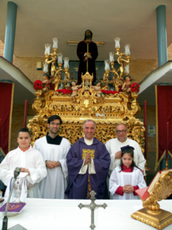 Celebración religiosa con sacerdotes y niños vestidos de blanco en un altar ornado.
