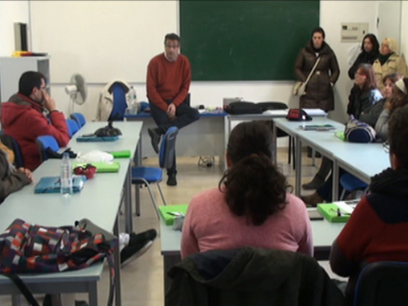 Una clase de idiomas con estudiantes y un profesor en una aula moderna.