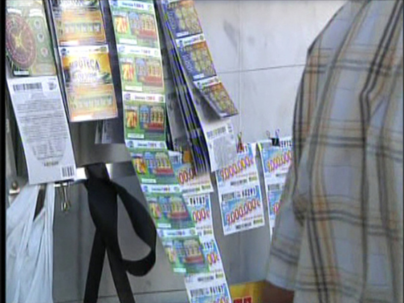 Un mostrador de lotería con diversas opciones de apuestas, junto a un paraguas colgando.
