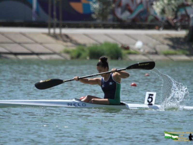 Competidora en canoa durante un evento deportivo en el río.