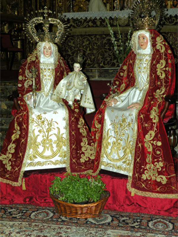 Imágenes religiosas de la Virgen María y el Niño Jesús, vestidos con trajes elaborados, posiblemente en una iglesia o santuario católico.