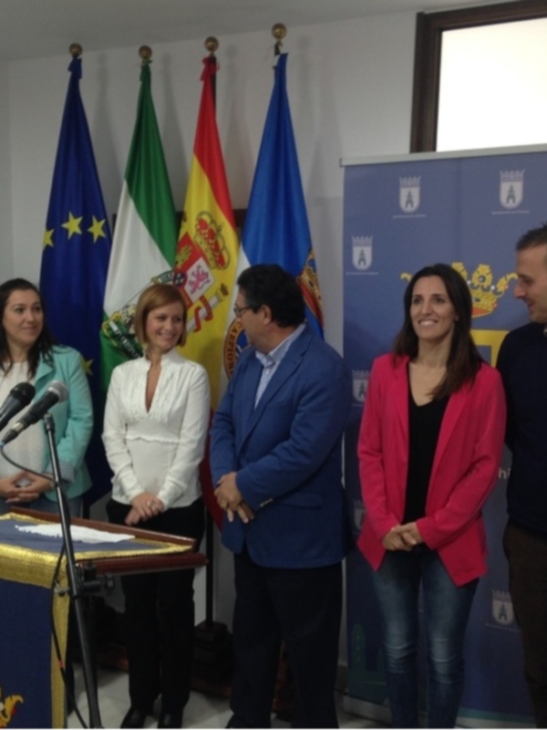 Presentación oficial en un evento con banderas y emblemas oficiales.