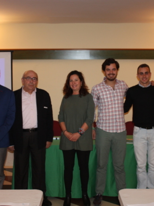 Grupo de personas posando juntos en una reunión o evento formal.