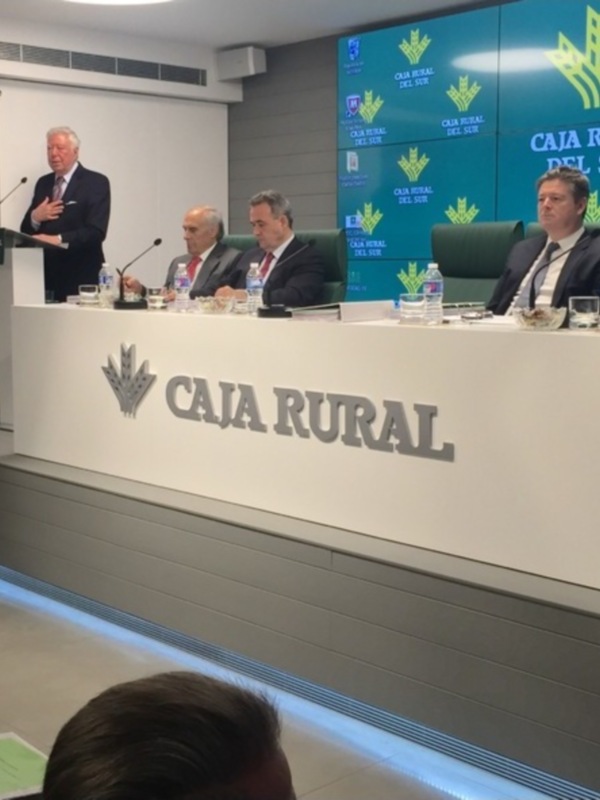 Conferencia de prensa en Caja Rural del Sur, con un panel de expertos y un discurso en el escenario.