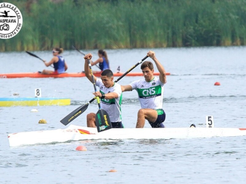 Competidores en canoa durante una carrera deportiva en un lago.
