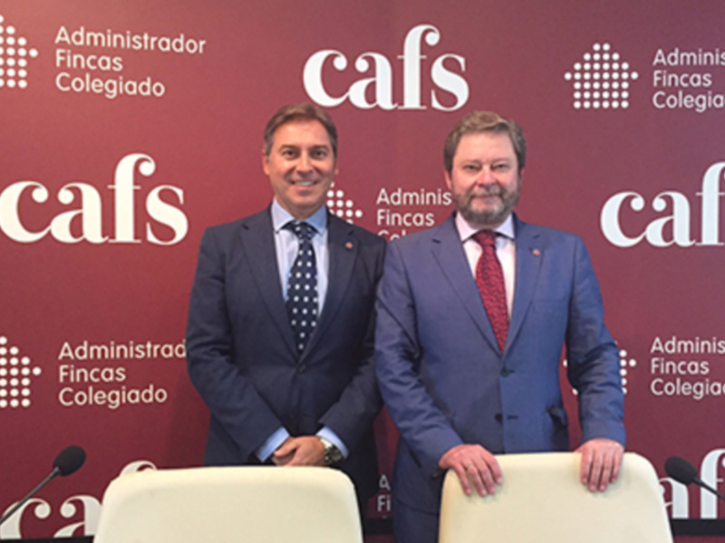 Dos hombres en trajes posan frente a un fondo con el logo de CAFS y el texto 'Administrador Fincas Colegiado'.