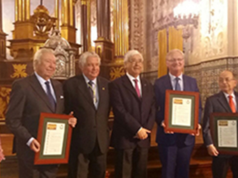 Premiación en un evento formal en un interior ornamental con personas sosteniendo certificados.