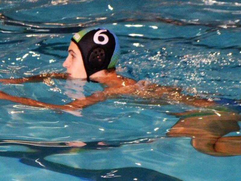Jugador de waterpolo nadando en piscina.