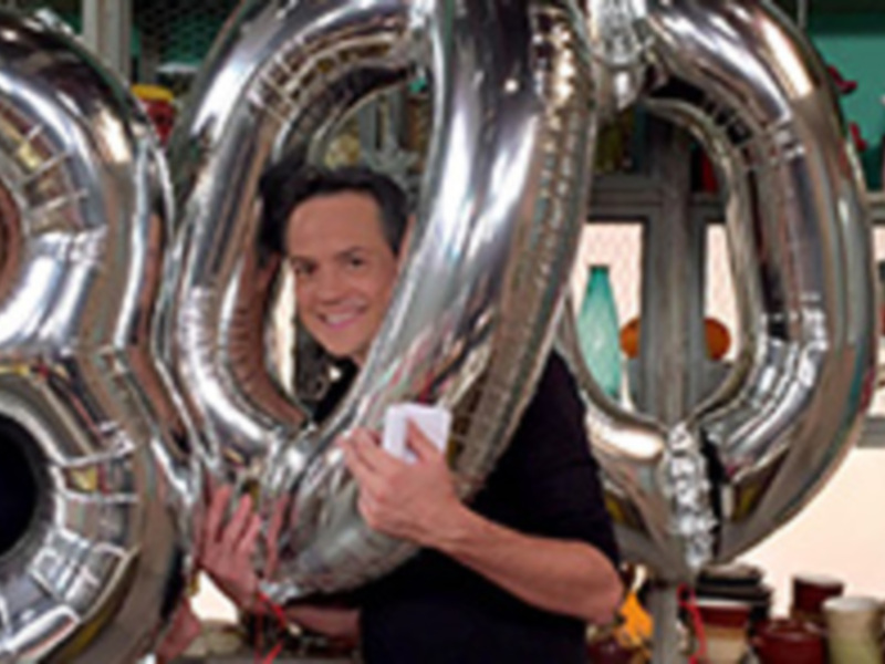 Dos personas celebran con globos gigantes que forman el número 300.