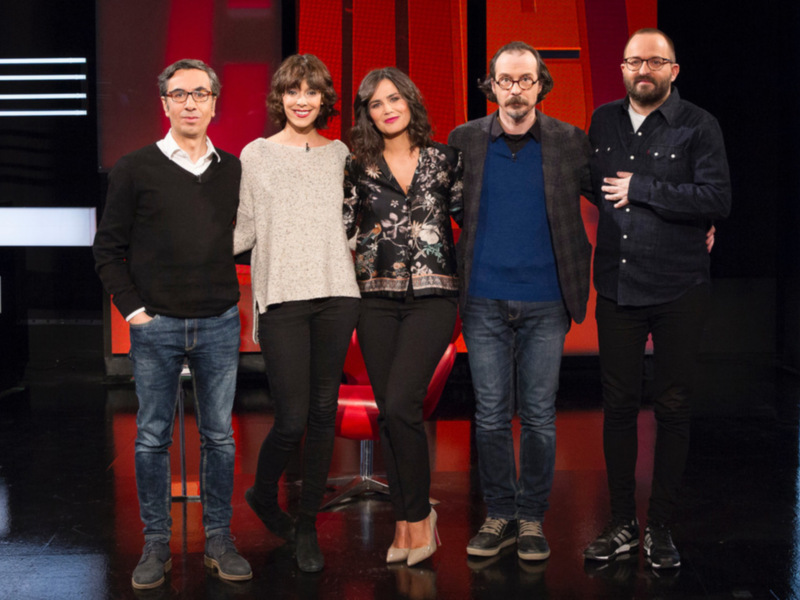 Cuarteto de presentadores en un estudio de televisión, posando juntos con confianza.