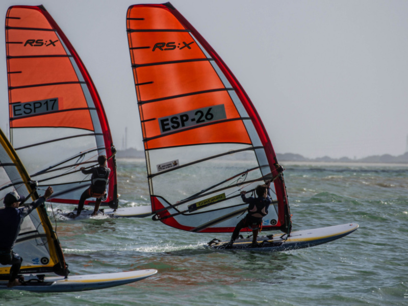 Windsurfers in action with RS:X sails, showcasing their skills on the waves.