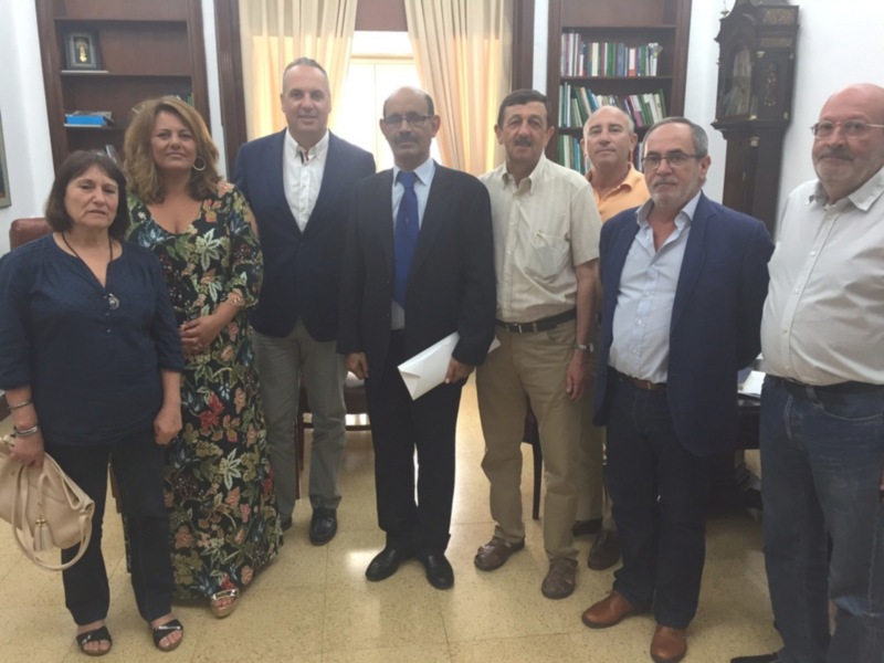 Reunión de trabajo en un entorno formal con varios profesionales y autoridades.
