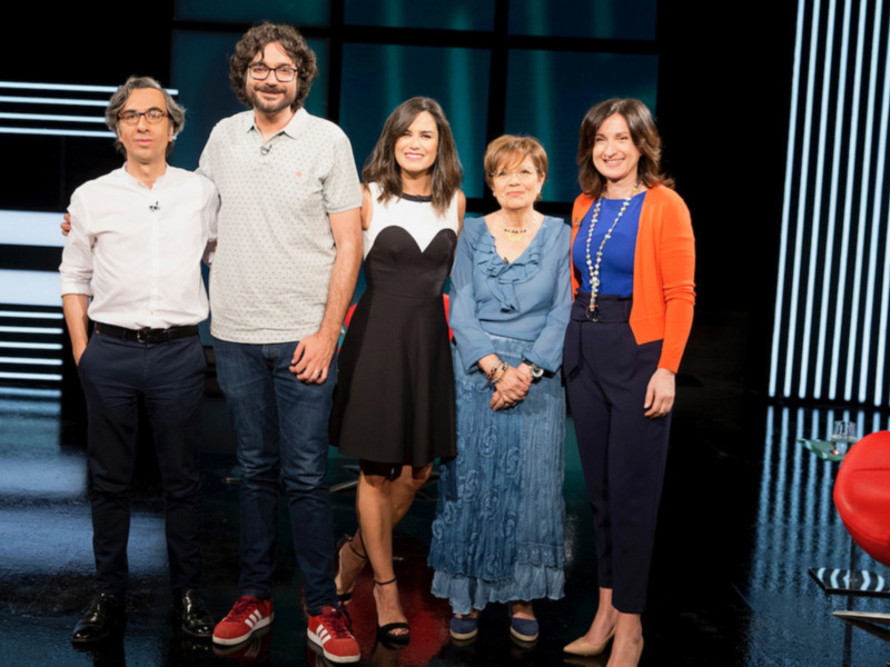 Grupo de personas en un escenario de televisión, posando juntos.
