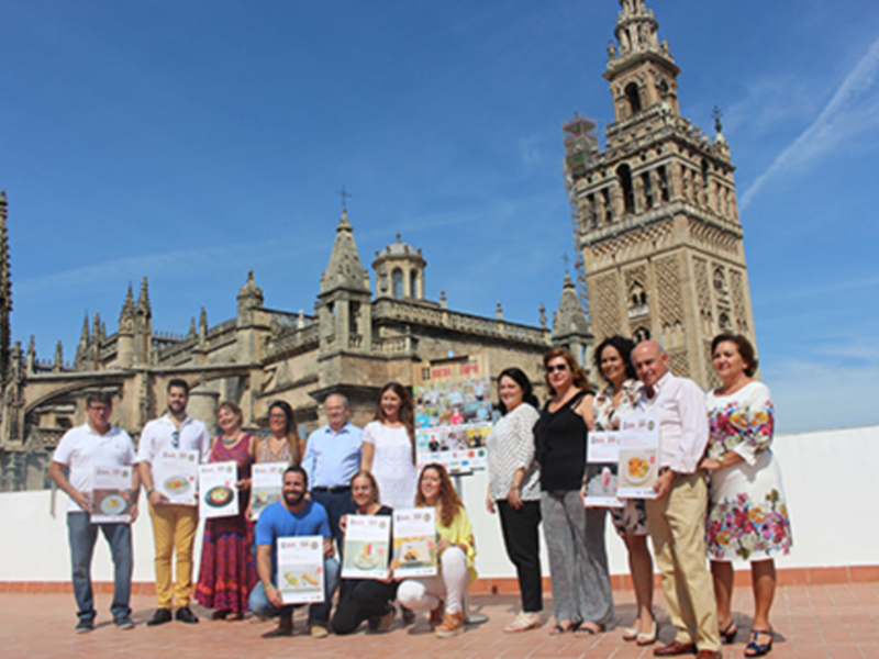 Gente posando con carteles frente a la Catedral de Sevilla, España.