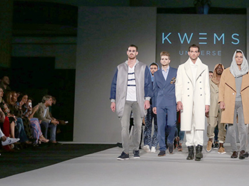 Desfile de moda masculina con modelos caminando por la pasarela en una presentación de la marca KWEMS.
