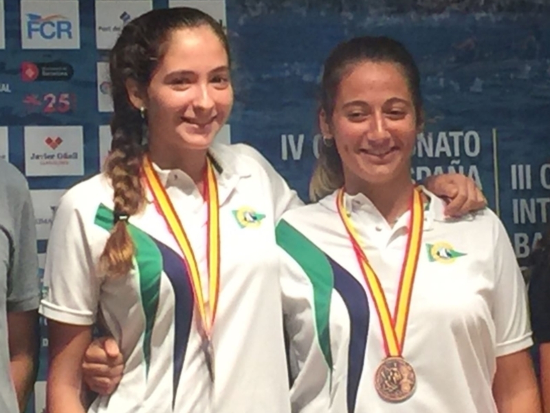 Dos atletas brasileñas posan con medallas en un evento deportivo.
