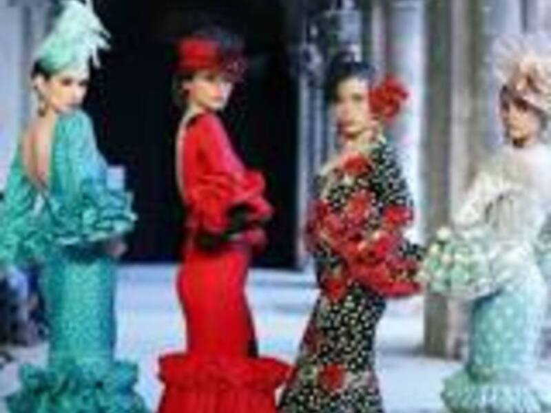 Desfile de moda con modelos en vestidos coloridos y elegantes en un entorno urbano.