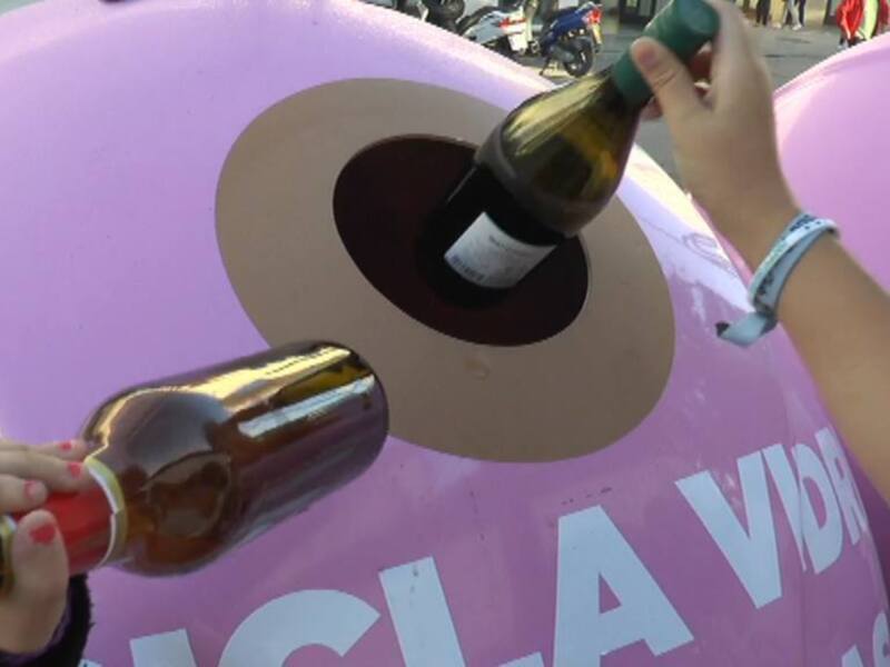 Un individuo vertiendo contenido de una botella en un contenedor de basura rosa, con el texto 'Vida' visible en el fondo.