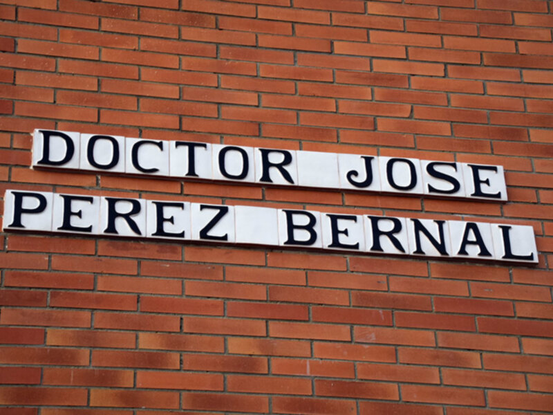 Un muro de ladrillos rojos con letras blancas que forman el nombre "DOCTOR JOSE PEREZ BERNAL".