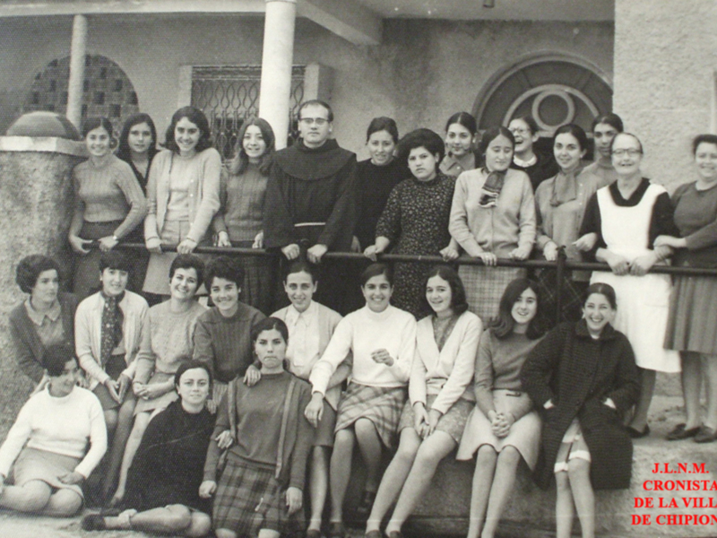 Grupal de estudiantes y profesores en Chipiona, España, posando en un balcón histórico.