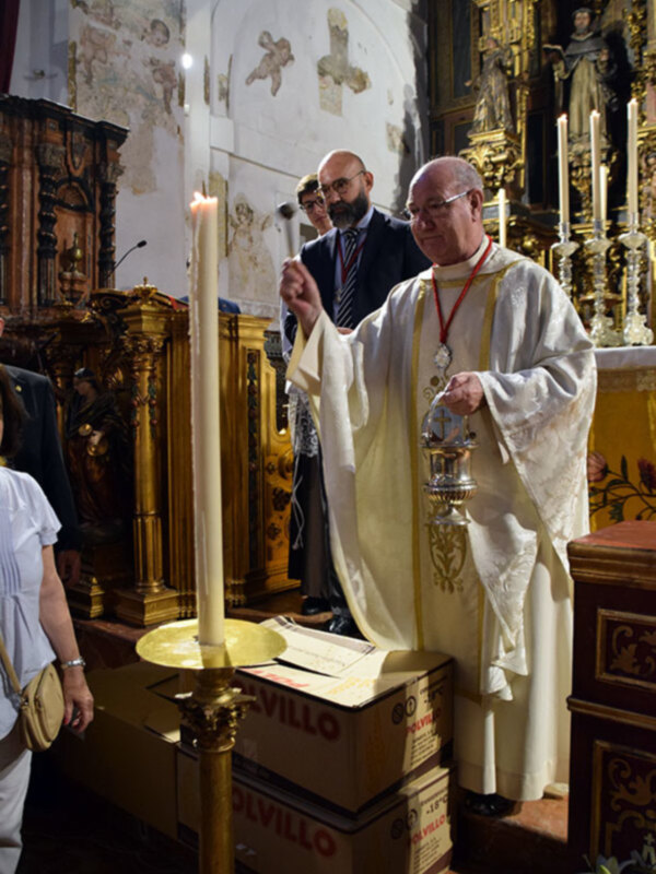 Un sacerdote realiza una bendición durante una ceremonia religiosa en un templo antiguo.