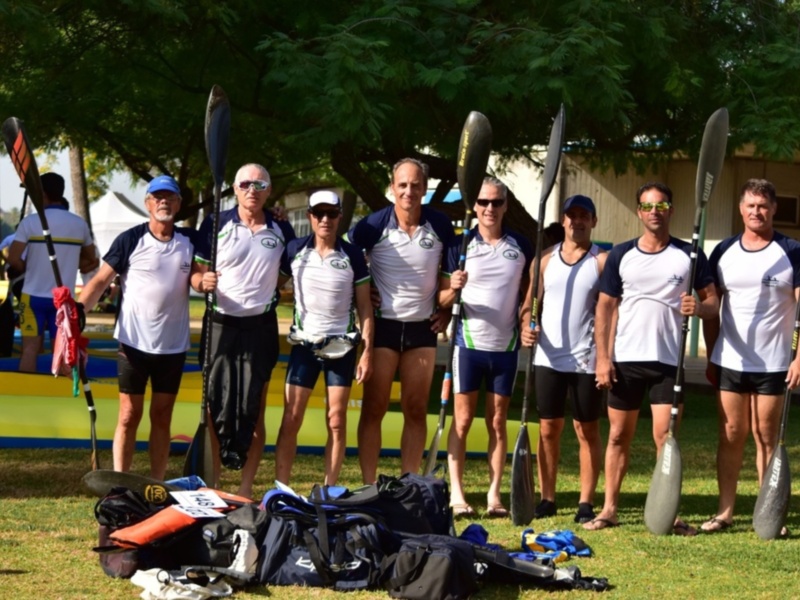 Equipo de remo listo para competir en un día soleado al aire libre.