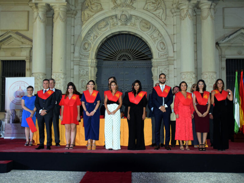 Celebración de graduación en un edificio histórico con estudiantes en vestimenta académica.