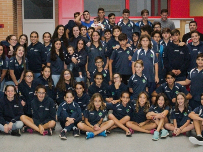 Equipo de jóvenes atletas en uniforme azul, posando para una foto de grupo en un entorno deportivo.