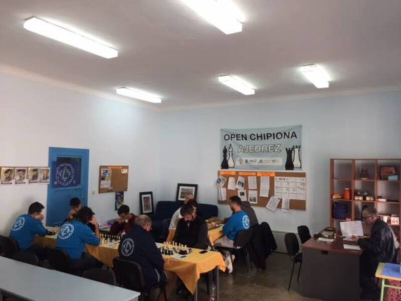 Participantes en el Open Chipiona de Ajedrez, jugando en un salón bien iluminado.