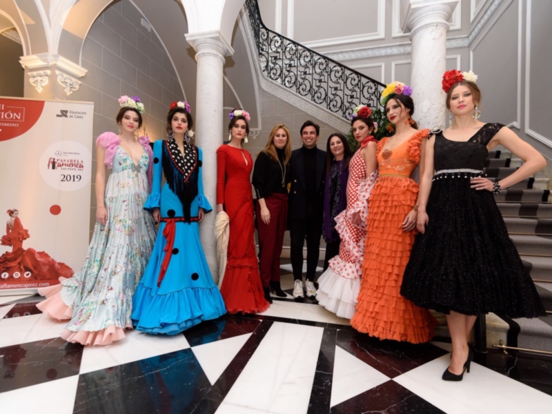 Desfile de moda flamenca en el Pasarela Flamenca Jerez 2019, con modelos y diseñadores en un elegante escenario.