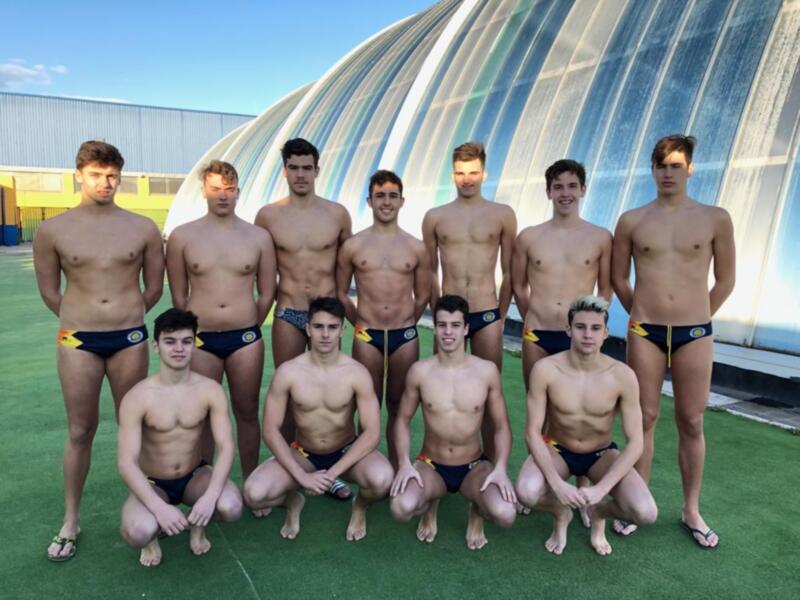 Equipo de natación masculino posando juntos en trajes de baño al aire libre.