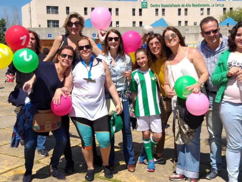 Grupo de personas celebrando con globos en un evento al aire libre en el Centro Especializado de Alto Rendimiento La Cartuja.